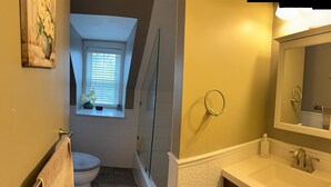 Une salle de bain avec des toilettes, une douche et un lavabo.