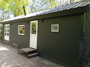 Un petit bâtiment d’un seul étage, doté d’un toit en métal, d’une porte et de deux fenêtres.