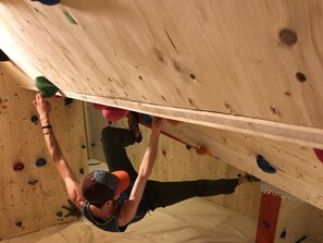 A person climbing a wooden wall with various colored holds. - Das Felaria, (Samnaun-Laret) by Interhome (Samnaun)