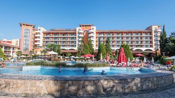 A hotel with a swimming pool, multiple balconies, and a casino sign.