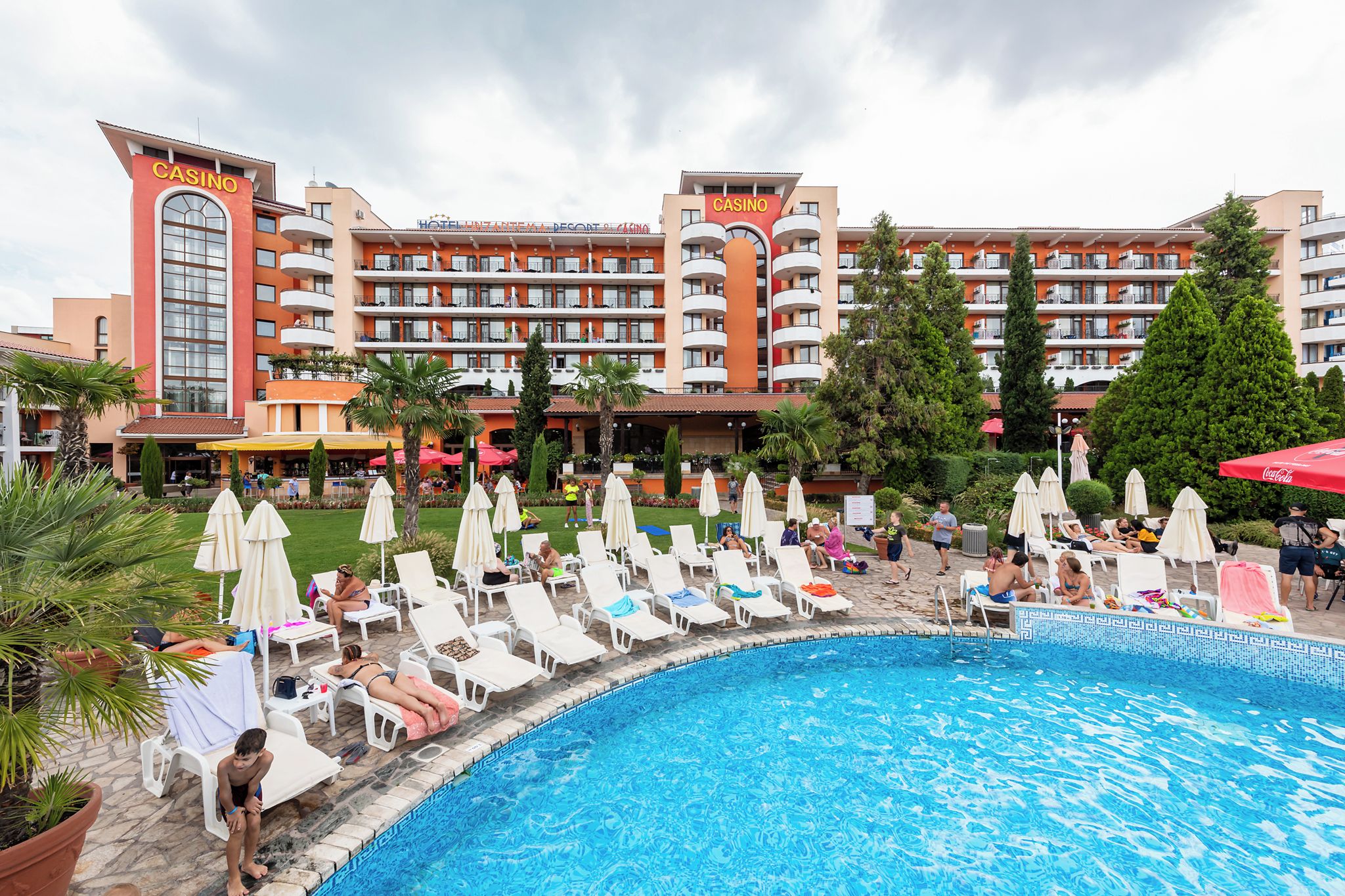 Un hotel con zona de piscina, varios balcones y un cartel de casino.