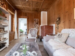 Un interior de madera con un sofá, un sillón y una mesa de centro con adornos.