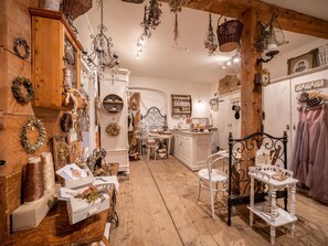 Een rustiek interieur met houten balken, een kroonluchter en diverse decoratieve objecten.