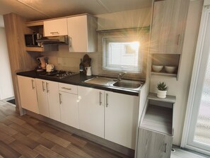 A compact kitchen with a sink, stove, and cabinets. - RBR 433 - Beach Resort Kamperland by Interhome (Kamperland)