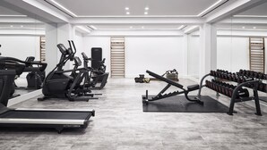 A modern gym with treadmills, elliptical machines, and weight benches. - Atlantica Beach Resort (Kos)