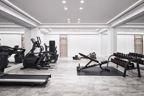 Uma academia moderna com esteiras, elípticos e bancos de musculação.