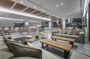 A modern lounge area with sofas, chairs, and tables, featuring a clean, contemporary design and ample seating. - Atlantica Beach Resort (Kos)