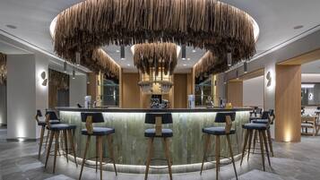 A modern bar area with a circular wooden ceiling design, bar stools, and a marble countertop.
