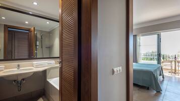 A modern bathroom with a sink, mirror, and shower.