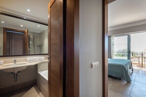 A modern bathroom with a sink, mirror, and shower. - Atlantica Beach Resort (Kos)
