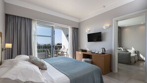 A modern hotel room with a large bed, a desk, a flat-screen TV, and a balcony with a view. - Atlantica Beach Resort (Kos)
