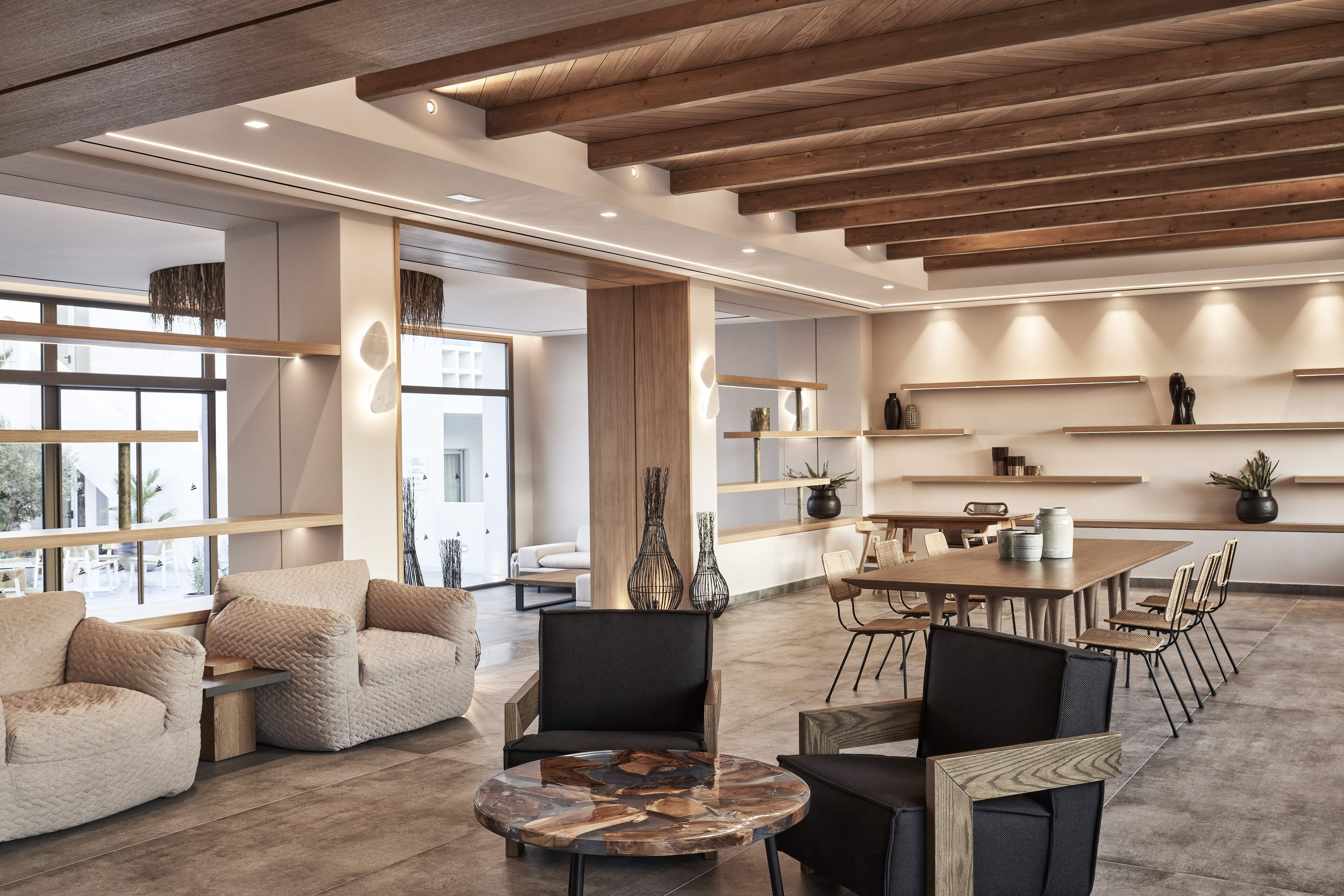 A modern interior with a wooden ceiling, a round coffee table, and a dining area with chairs and a table.