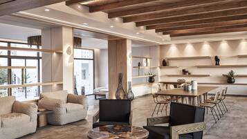 A modern interior with a wooden ceiling, a round coffee table, and a dining area with chairs and a table.