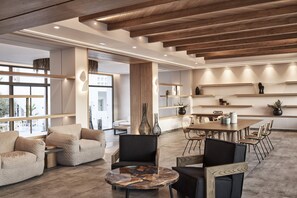 Un interior moderno con techo de madera, una mesa de centro redonda y una zona de comedor con sillas y una mesa.