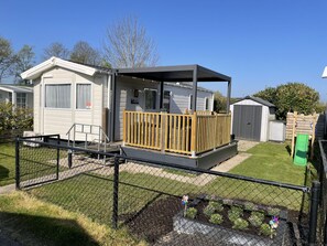 A mobile home with a fenced yard, a small deck, and a shed. - RBR 1132 - Beach Resort Kamperland by Interhome (Kamperland)