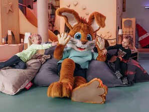 Ein großes, weiches Stofftier in einem Kinderspielbereich.
