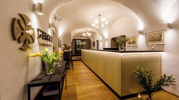 Een hotelgang met een receptiebalie, een bar en een keuken op de achtergrond.