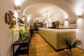 Un pasillo de hotel con una recepción, una zona de bar y una cocina al fondo.