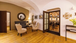 Un interior moderno con sofá, sillas, zona de comedor y un espejo grande.