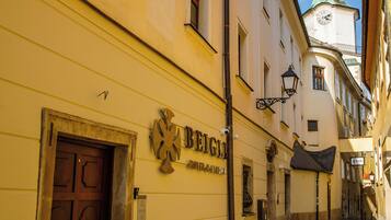 Una calle adoquinada con edificios, uno con un letrero que dice 'BEIGEL'.