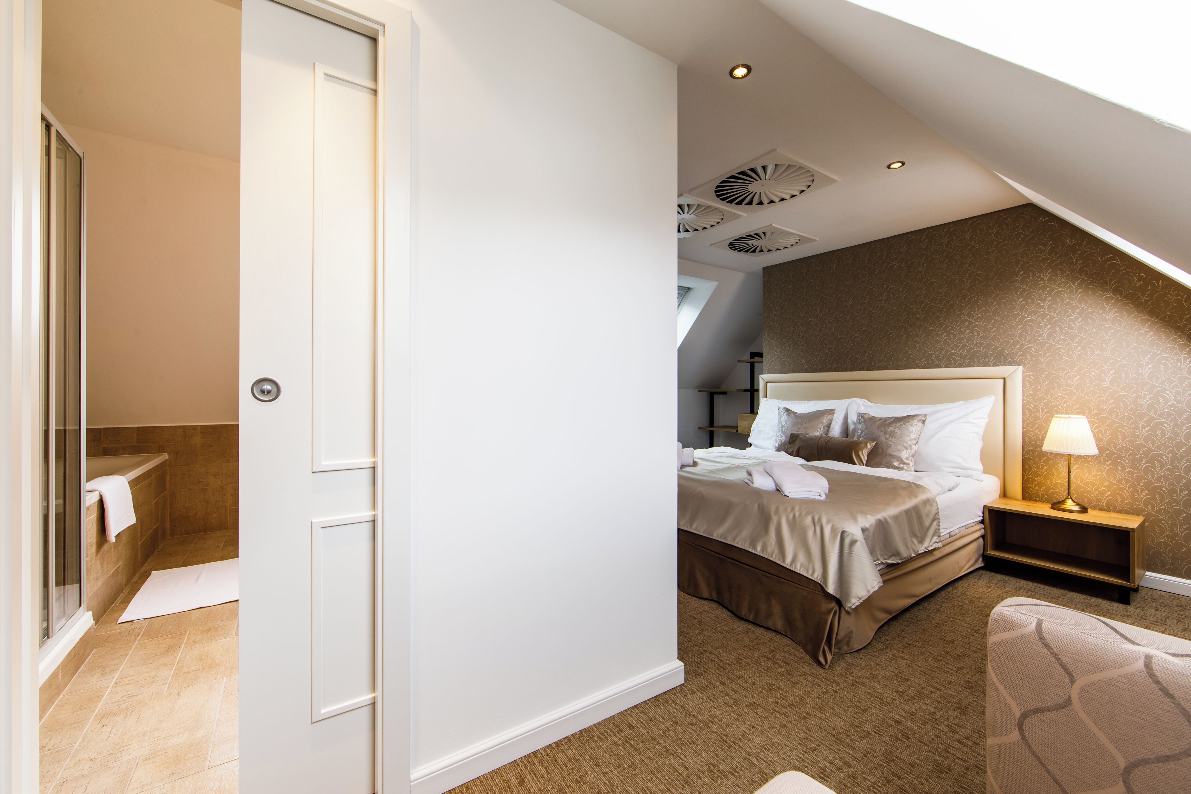 Un dormitorio con cama, mesita de noche y ventana.