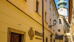 Una calle adoquinada con edificios, uno con un letrero que dice 'BEIGEL'.