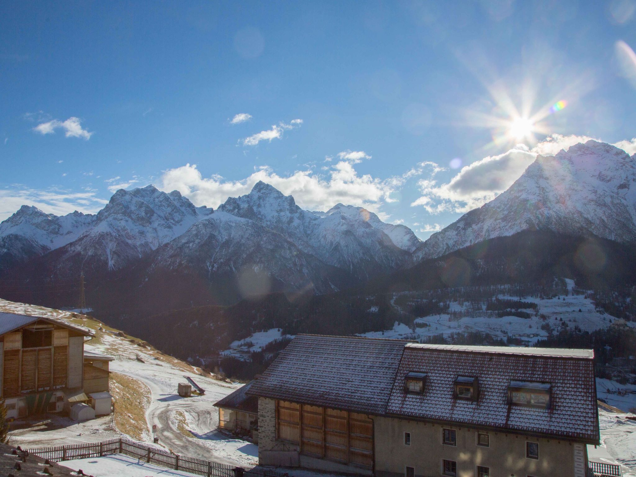A mountain landscape with snow-covered peaks and a clear sky.
