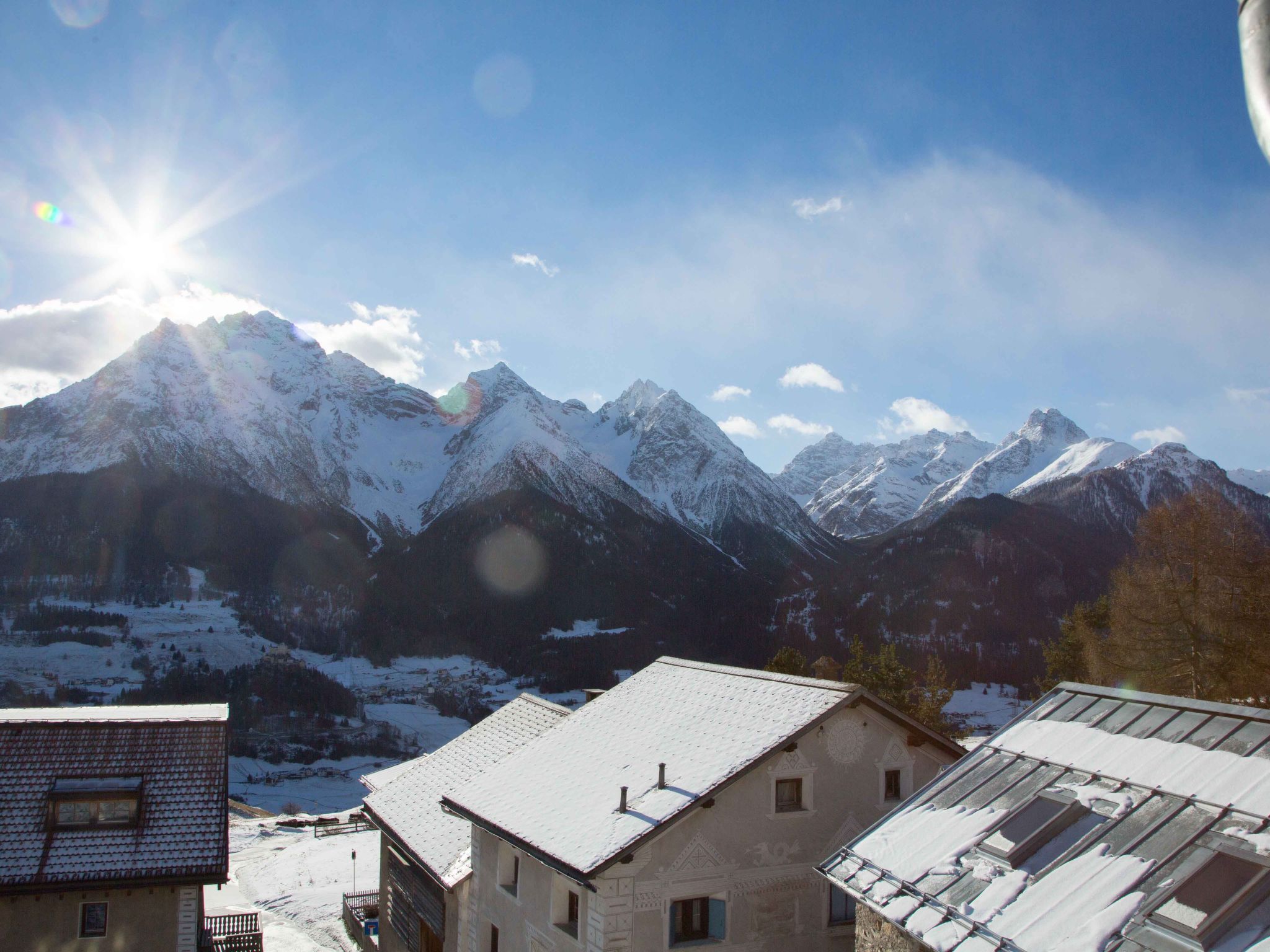 A mountain landscape with snow-covered peaks and a clear sky.