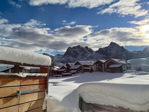A snow-covered mountain landscape with wooden cabins and a clear sky. - Chasa Cumulus/HP Ferienwohnung Sainas 139 A, (Ftan) by Interhome (Ftan)