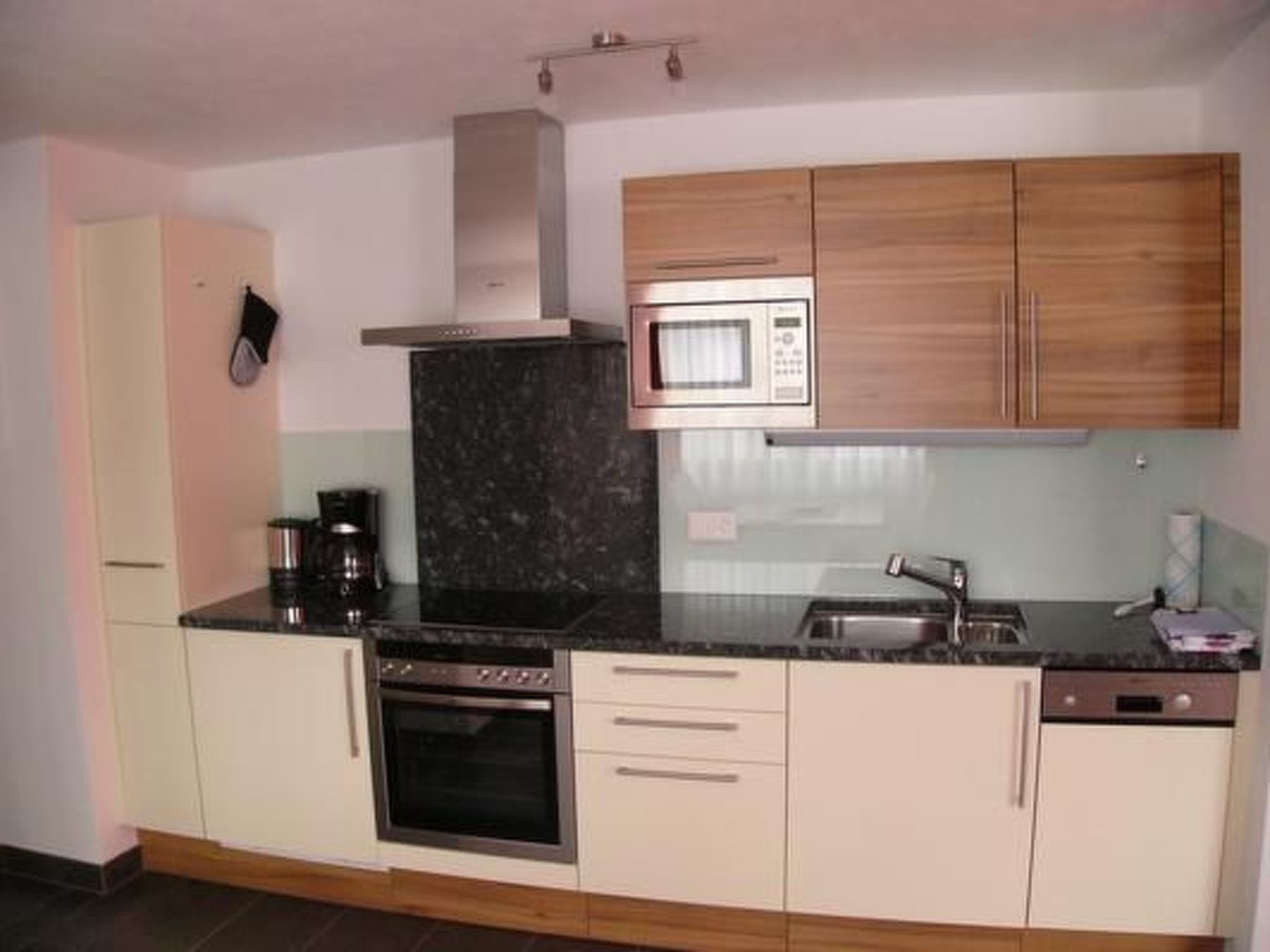 A kitchen with a stove, oven, microwave, and a sink.