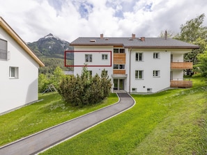 A two-story building with a white facade, multiple windows, and a red outline marking a section. - WÜEST, (Scuol) by Interhome (Scuol)