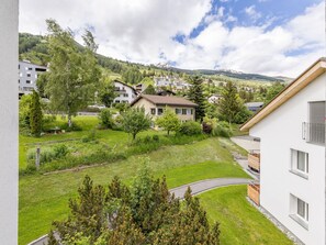 Bairro residencial com casas, gramado verde e uma montanha ao fundo.
