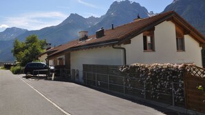 Una casa con tetto spiovente, un garage e vista sulle montagne.