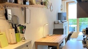 Cucina con piano di lavoro, lavandino e fornelli. Una finestra permette l'ingresso di luce naturale.