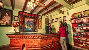 A reception desk with framed certificates, a cash register, and a bookshelf with various items. - Kathmandu Eco (Kathmandu)