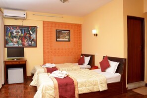 A hotel room with two beds, a TV, a small fridge, and artwork on the walls. - Kathmandu Eco (Kathmandu)