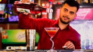A person pouring a drink into a martini glass. - Kathmandu Eco (Kathmandu)