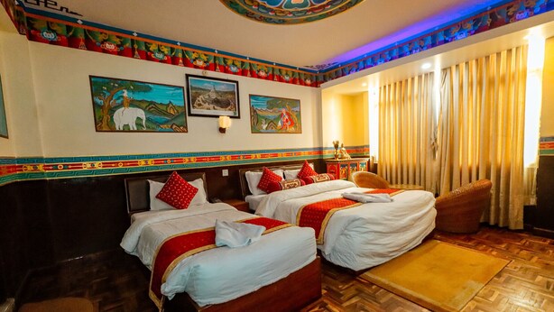 A hotel room with two beds, wooden flooring, and decorative wall art. - Kathmandu Eco (Kathmandu)