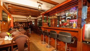 A bar area with wooden bar stools, a bartender, and a well-stocked bar counter. - Kathmandu Eco (Kathmandu)