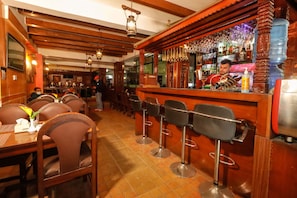 A bar area with wooden bar stools, a bartender, and a well-stocked bar counter. - Kathmandu Eco (Kathmandu)