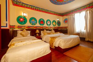 A hotel room with two beds, a decorative wall with circular artwork, a wooden floor, and a window with curtains. - Kathmandu Eco (Kathmandu)