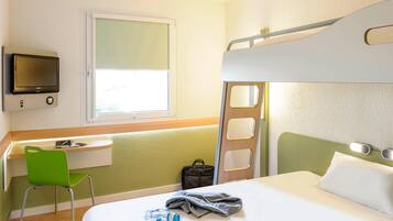 Een stapelbed met een bureau en stoel, een televisie en een raam.