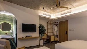 A hotel room with a bed, a TV, a plant, a wooden ladder, and a shower area. - The Leaf Boutique Hotel (Da Nang)