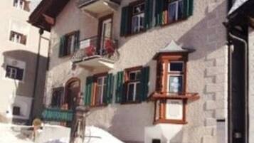 Ein mehrstöckiges Gebäude mit verschneitem Dach und einem Balkon.