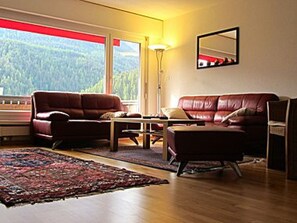 A living room with a sofa, armchair, coffee table, and a rug. - Brentsch Park, (Scuol) by Interhome (Scuol)