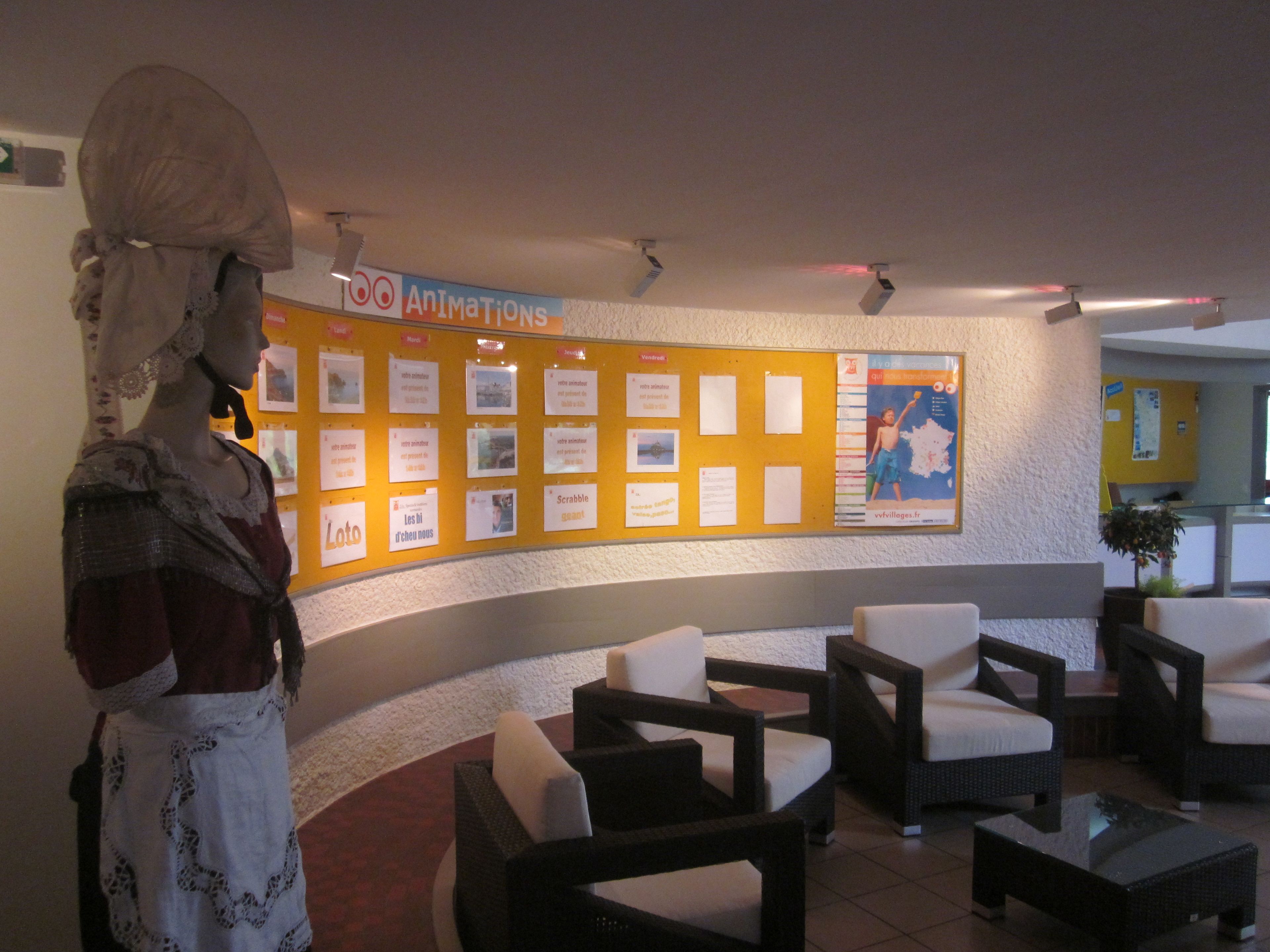 Un hall d’entrée avec un panneau d’affichage, un espace détente et une statue.