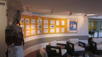 Un hall d’entrée avec un panneau d’affichage, un espace détente et une statue.