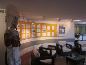Un hall d’entrée avec un panneau d’affichage, un espace détente et une statue.