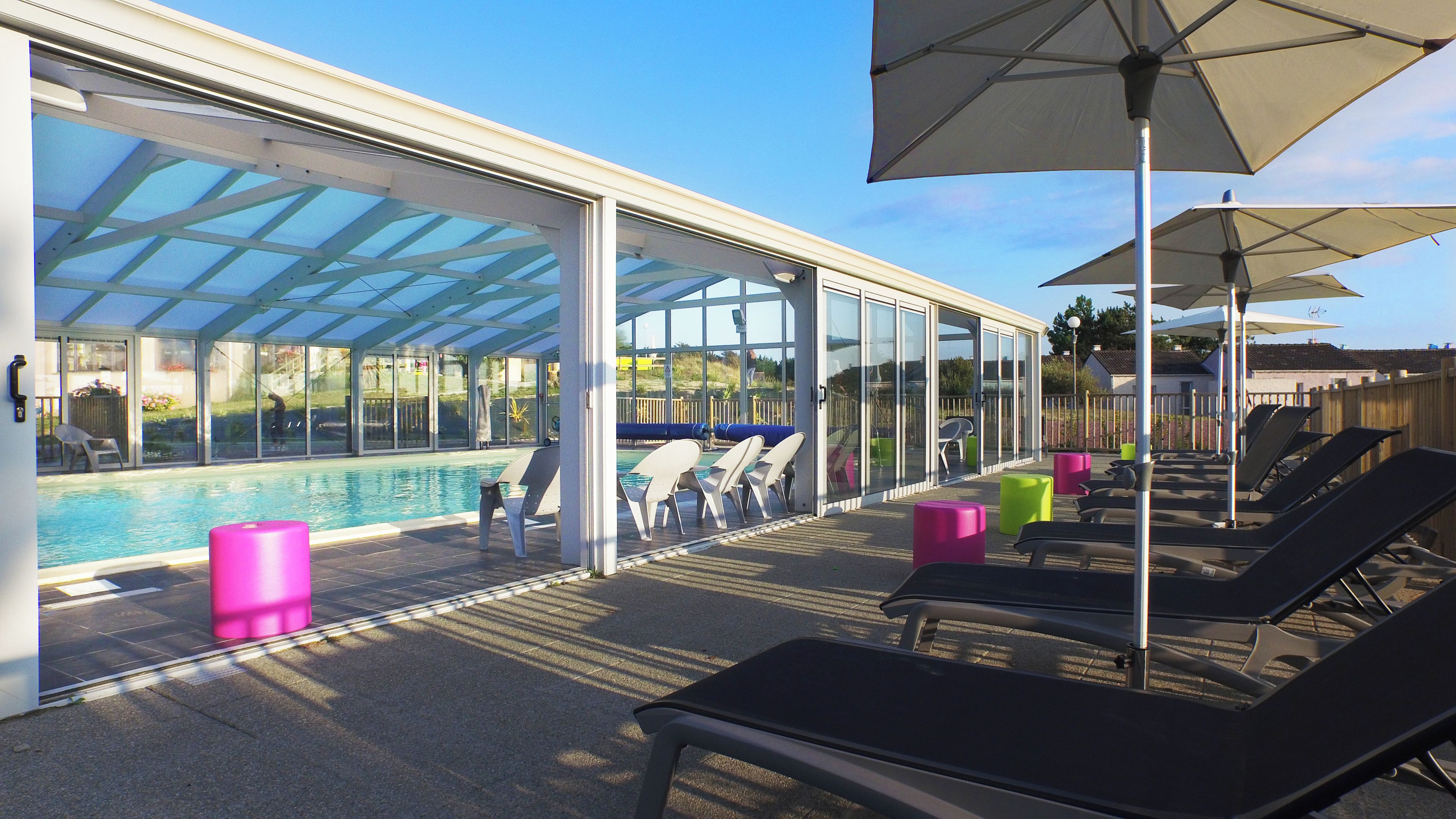 Ein Poolbereich mit Liegestühlen und Sonnenschirmen.