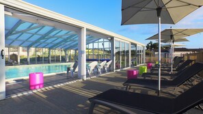 A covered pool area with lounge chairs and umbrellas. - Vvf Villages Portbail (Port-Bail-sur-Mer)